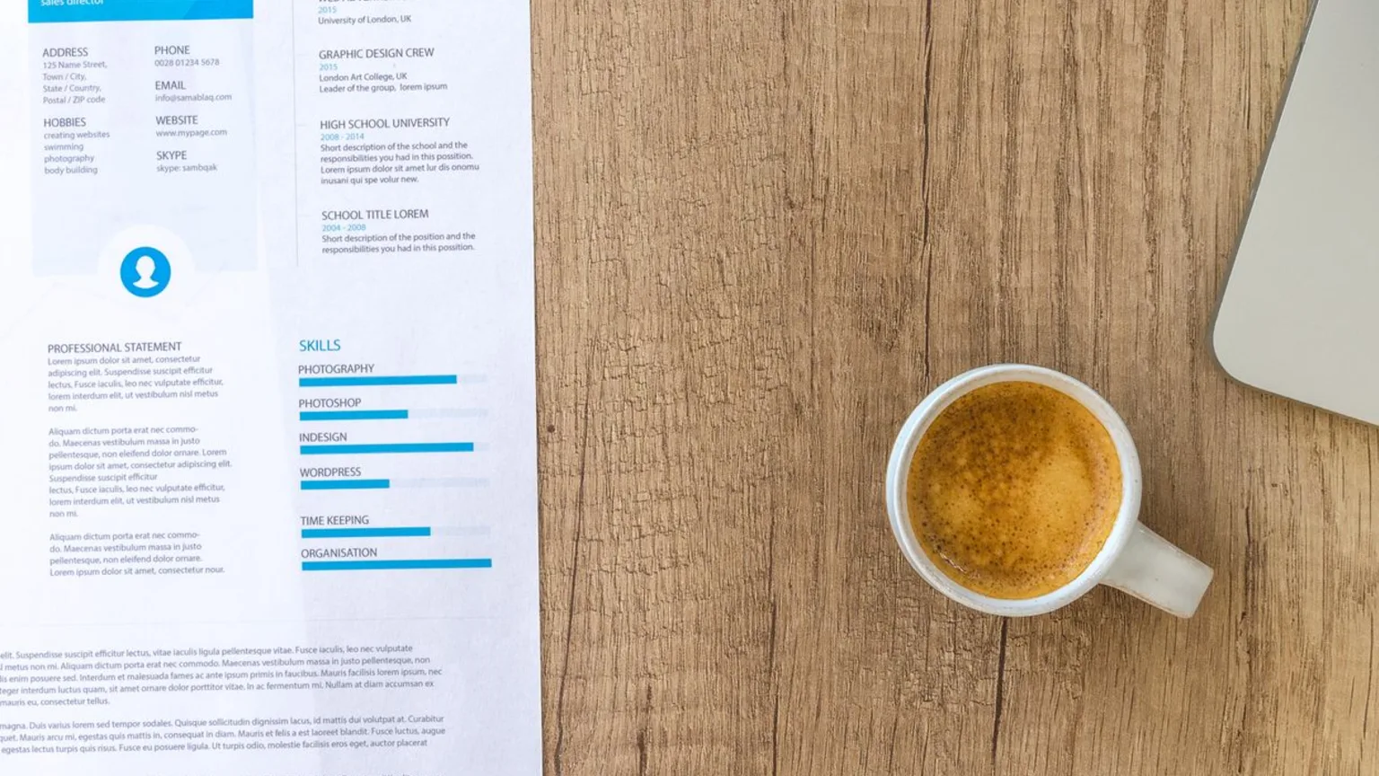 CV imprimé posé sur un bureau à côté d'un clavier et d'une tasse de café