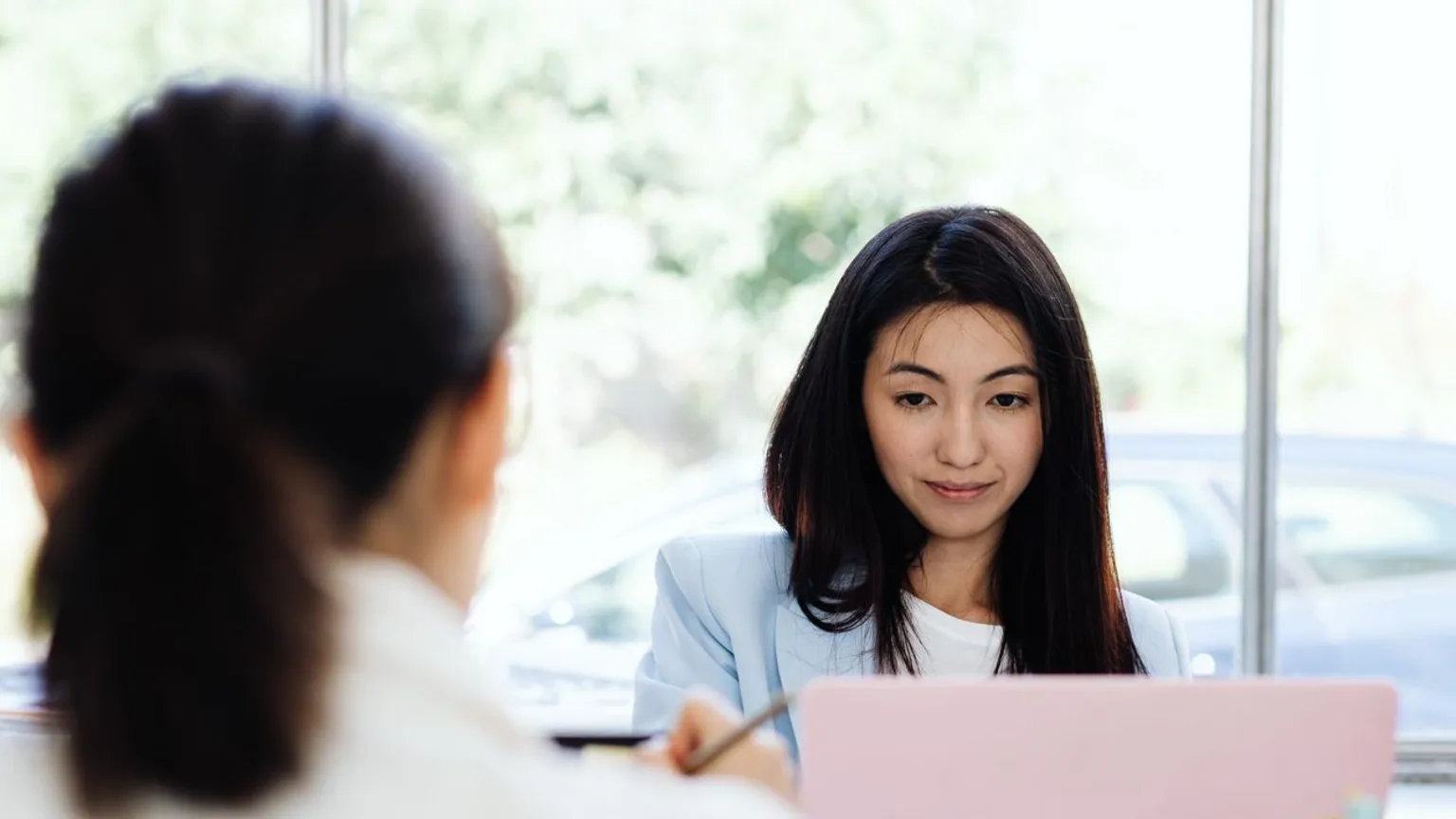 Deux professionnelles consultant ensemble des profils de candidates sur un ordinateur portable